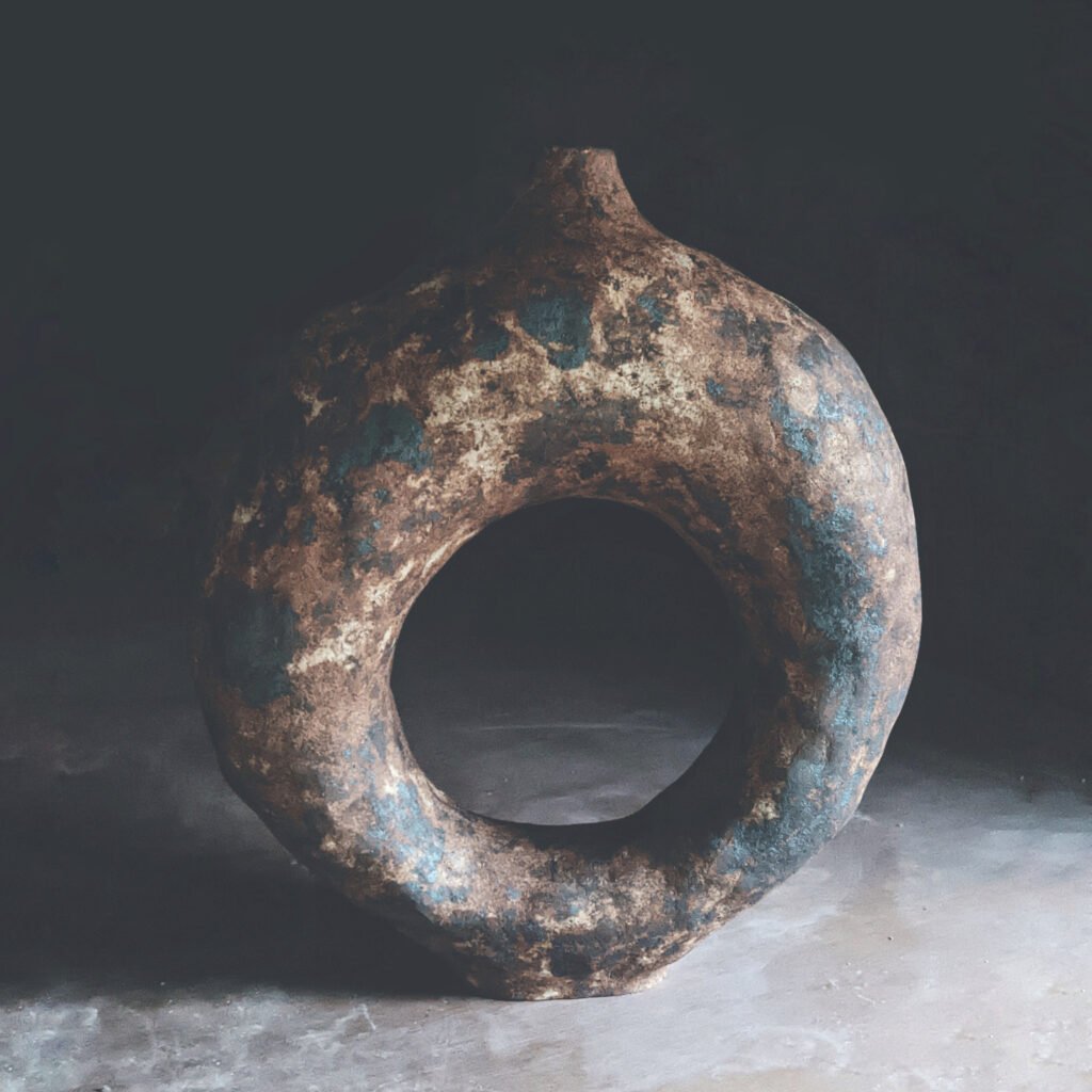 Serie Tótem: pieza anular de cerámica primitiva con textura granulada en tonos tierra y azul verdoso