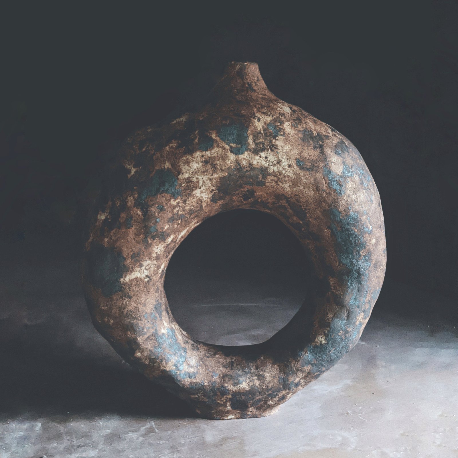 Serie Tótem: pieza anular de cerámica primitiva con textura granulada en tonos tierra y azul verdoso