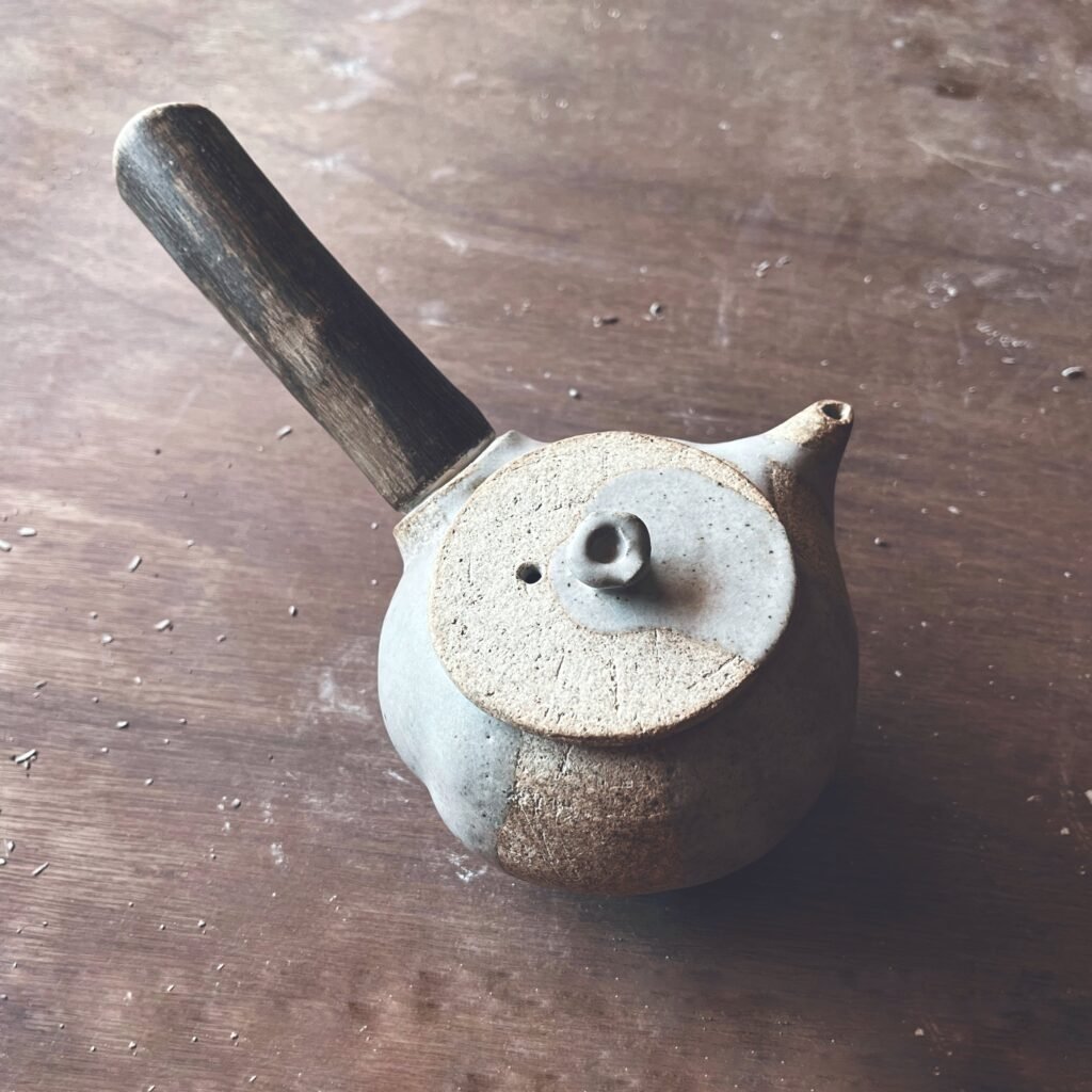 Tetera de gres claro con asa de madera y tapa sin esmaltar, para la ceremonia del té